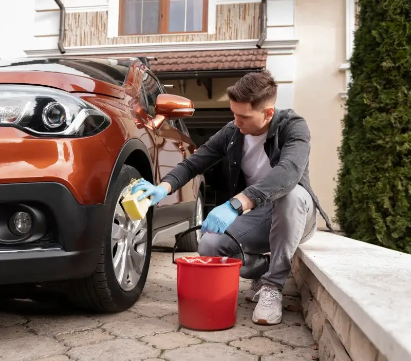 Lavage auto à domicile Saint-Germain-sur-Ay : professionnel intervenant sur un véhicule
